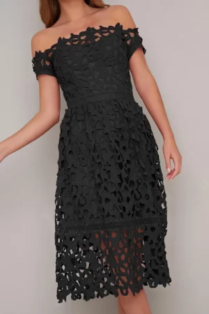 Vestido negro corto elegante con hombros descubiertos, tela de fino encaje, ceñido en la parte del dorso, falda amplia con transparencias a nivel de las rodillas. Cómo combinar un little black dress (mini vestido negro).